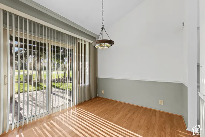 Vaulted ceiling, wood-finish flooring, glass sliding door, exterior patio, and built-in decorative lighting