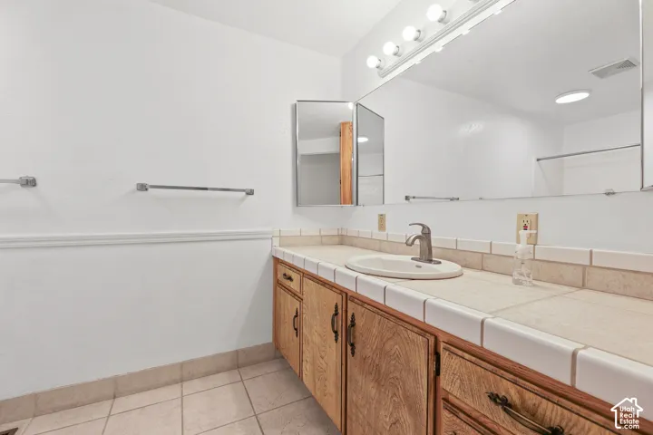 Single vanity with wood-finish cabinetry and brass-tone hardware