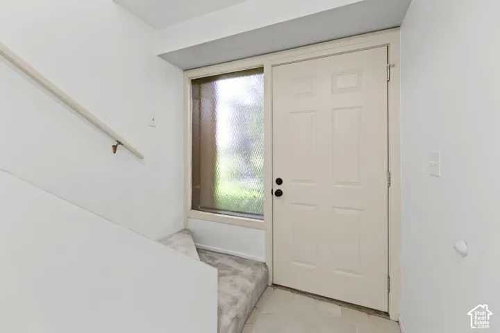Entryway featuring a paneled door, textured glass sidelight, and hexagonal tile flooring