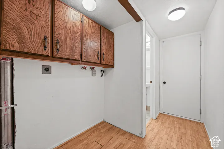 Wood-finish flooring, overhead cabinetry, and flush-mount lighting fixtures