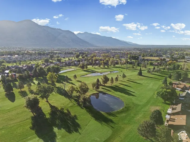 Expansive golf course setting featuring manicured greens and multiple water features