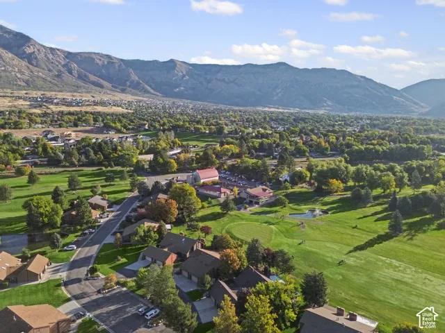 Expansive mountain backdrop, established neighborhood setting, mature trees, manicured golf course, and residential properties
