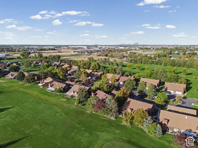 Expansive golf course setting featuring manicured greens, mature trees, and a residential community