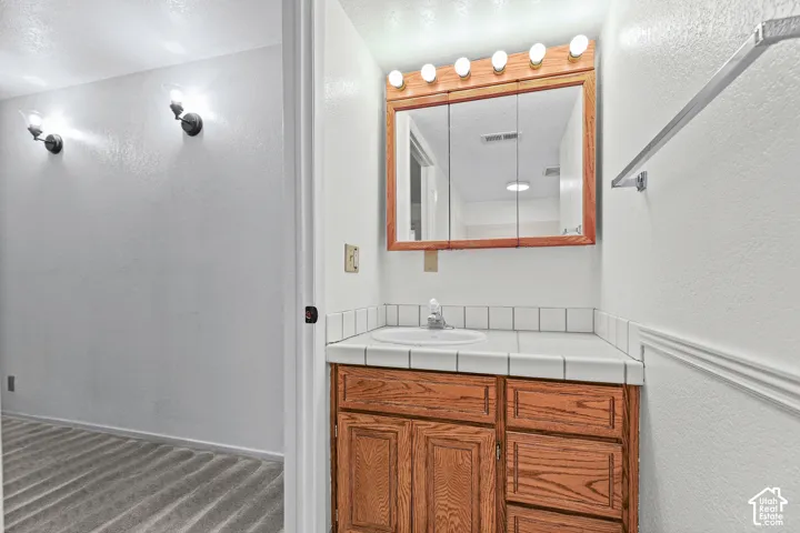 White tile countertop vanity with an integrated sink