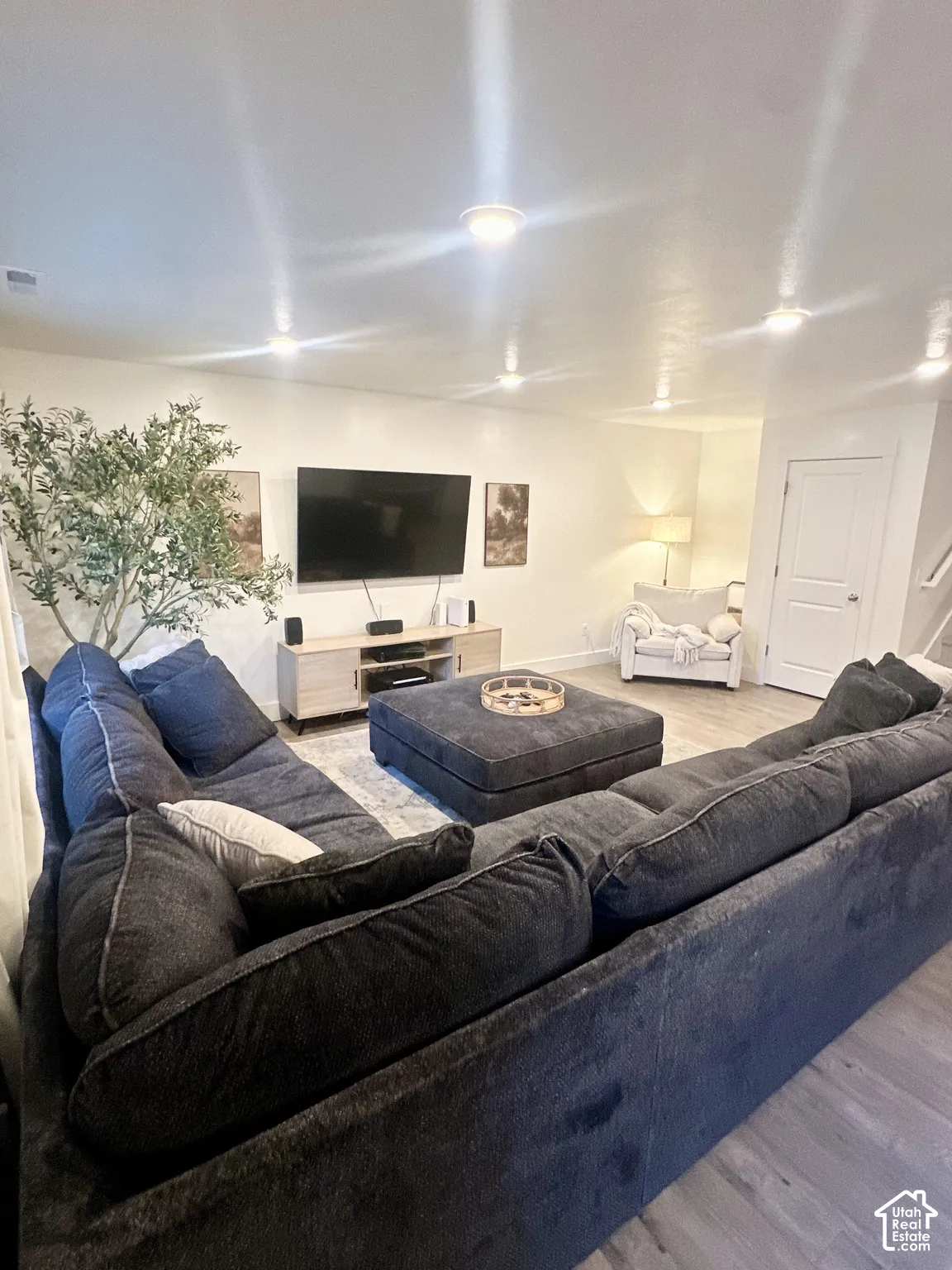 Recessed ceiling lighting, wood-finish flooring, and white walls