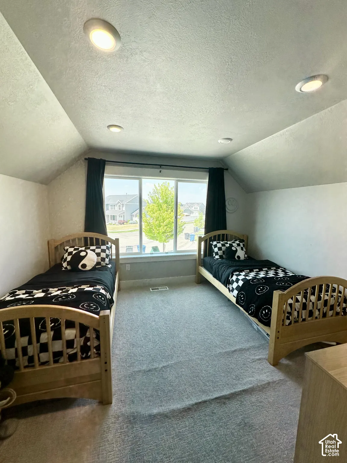 Sloped ceiling featuring recessed lighting, large window, and light-toned carpet