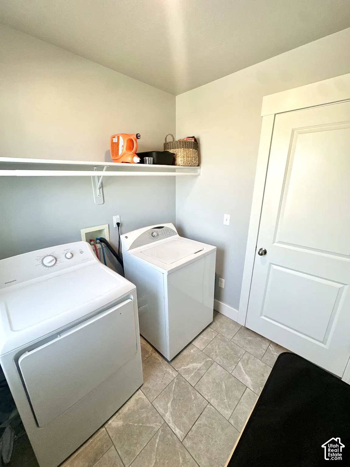 Laundry area featuring ceramic tile flooring, built-in shelving, and a white paneled door