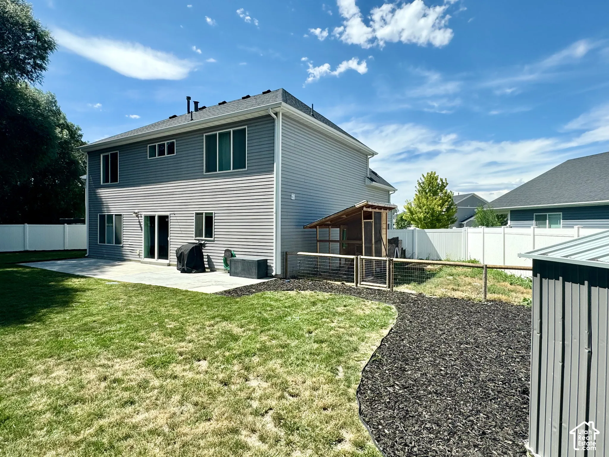 Two-story exterior with horizontal siding, a private backyard, a paved patio, and a privacy fence