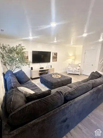 Recessed ceiling lighting, wood-finish flooring, and white walls