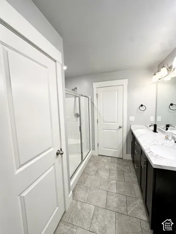 Dual vanity with undermount sinks, stone-look countertop, and dark wood-finish cabinetry