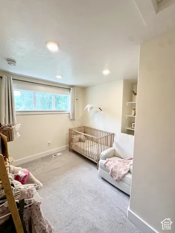 Recessed lighting, light-toned walls, and a built-in shelving unit