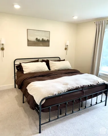 Recessed ceiling lighting, dual wall-mounted sconces, and neutral wall paint