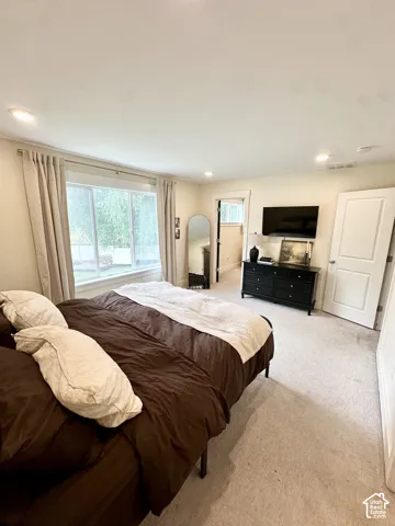 Wall-to-wall carpeting with recessed lighting, large windows, and a built-in dresser