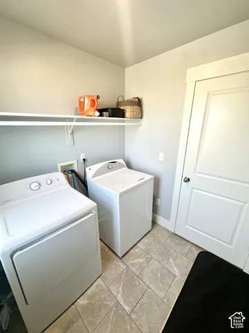 Laundry area featuring ceramic tile flooring, built-in shelving, and a white paneled door