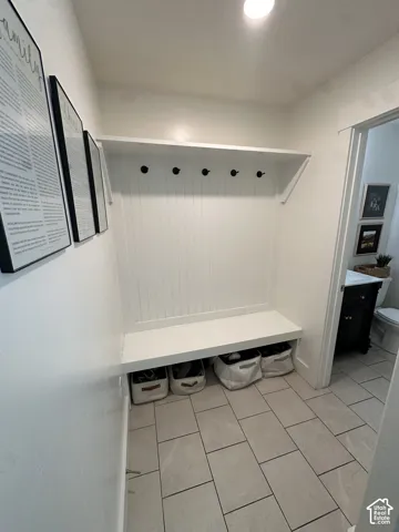 Built-in bench with beadboard paneling, integrated storage, and overhead shelving