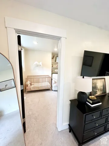 Carpeted flooring throughout, recessed ceiling lighting, and wide white door trim