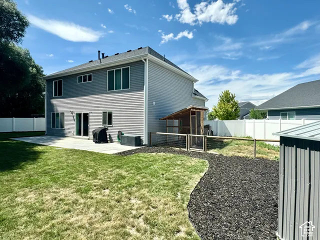 Two-story exterior with horizontal siding, a private backyard, a paved patio, and a privacy fence