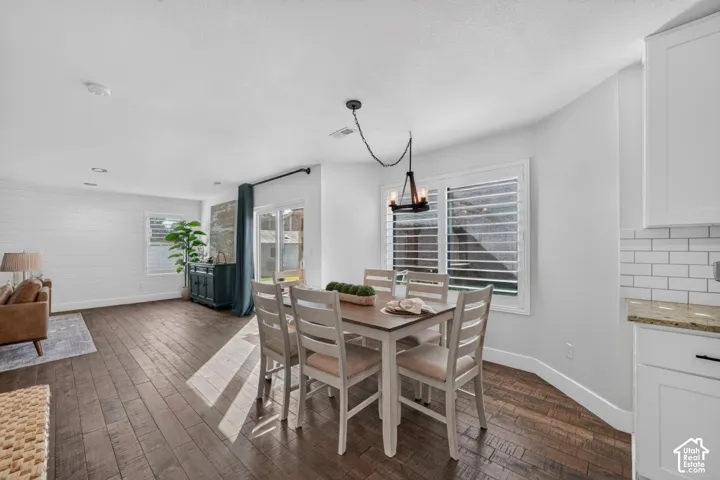 Wood-finish flooring, white shiplap wall, recessed lighting, white kitchen cabinetry, and subway tile backsplash