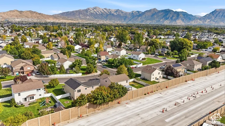 Residential neighborhood with established homes, mature trees, and mountainous backdrop