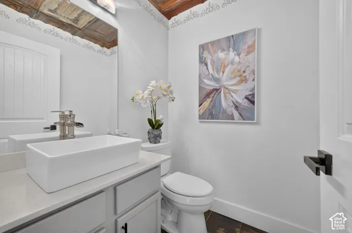 White rectangular vessel sink with a brushed nickel faucet, light-toned countertop, and white cabinetry