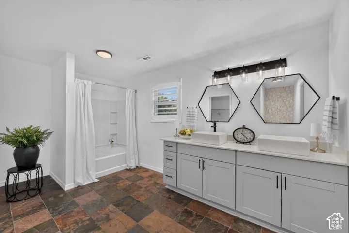 Dual vanity with rectangular vessel sinks, light gray cabinetry, and stone-look countertops