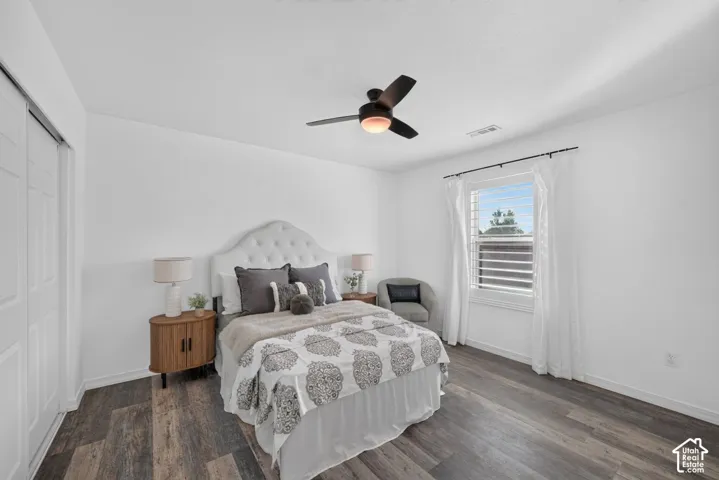 White paneled bi-fold closet doors, wood-finish flooring, and a ceiling fan with integrated lighting