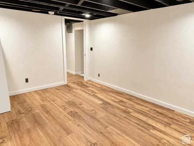 Neutral-toned walls paired with wood-finish flooring and an exposed industrial-style ceiling