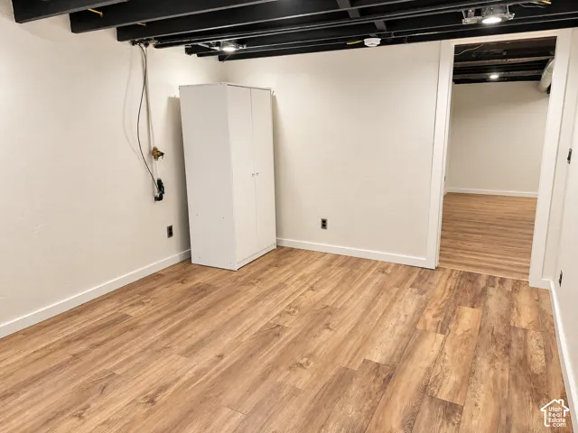 Wood-finish flooring, exposed painted ceiling joists, and recessed lighting