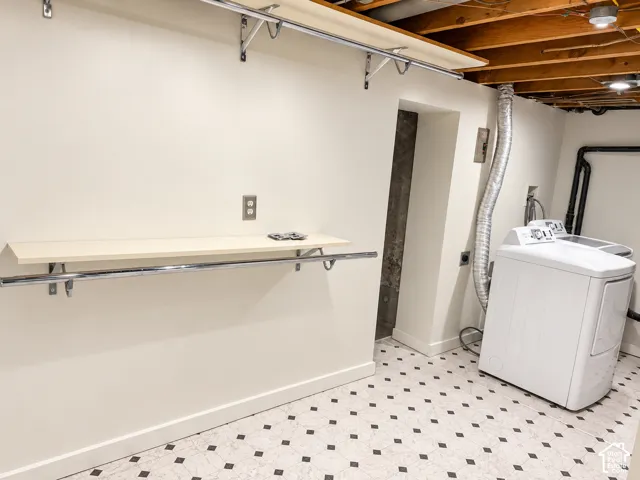 Utility area featuring an exposed beam ceiling, built-in shelving, washer/dryer