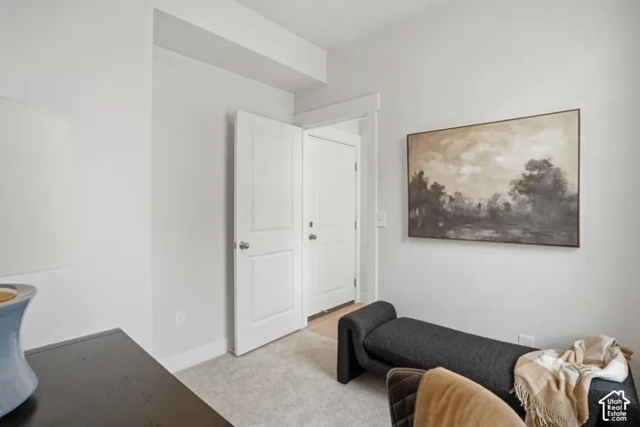 Recessed ceiling beam, light-colored carpeting, white baseboards, and white paneled doors