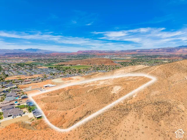Expansive undeveloped lot with varied topography and distant mountain formations