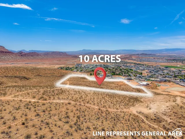 Expansive 10-acre lot featuring surrounding residential areas, distant mountain ranges, and clear skies