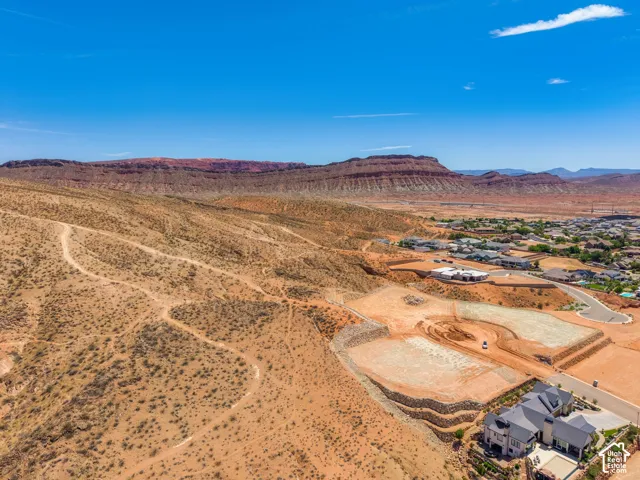 Expansive desert terrain with distant red rock formations and developed residential areas