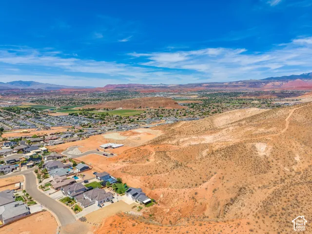 Expansive desert landscape with scattered residential development and distant mountains under a clear sky
