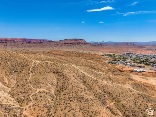 Expansive desert landscape featuring natural terrain and distant residential areas