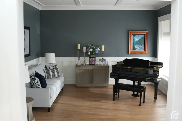 Wood-finish flooring, wainscoting, crown molding, and recessed lighting create a refined atmosphere