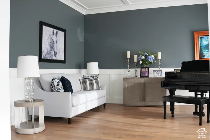 Hardwood-style flooring, wainscoting, crown molding, and a built-in console cabinet