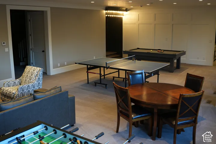 Spacious recreation room featuring carpet flooring, recessed lighting, and wall paneling
