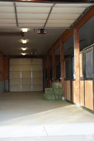 Garage space with concrete flooring, automatic overhead door, and recessed lighting