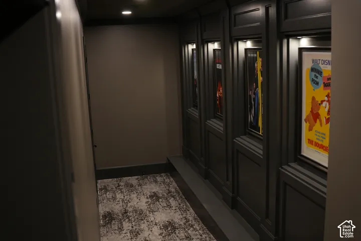 Recessed ceiling lighting, dark trim, paneled wall detailing, and integrated display lighting