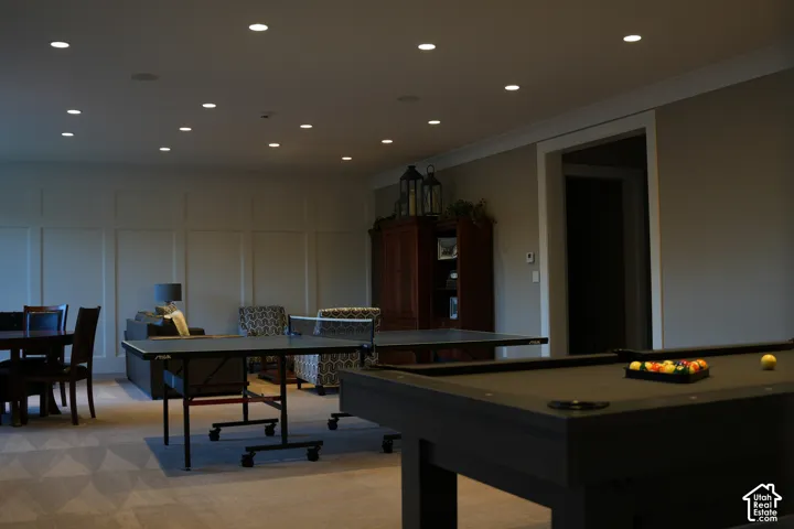 Recessed ceiling lighting, crown molding, wall paneling, and carpeted flooring