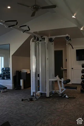 Sloped ceiling with recessed lighting, ceiling fan, and patterned carpet flooring