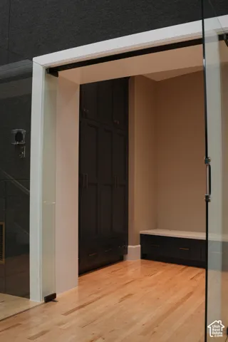 Light wood-finish flooring with a dark built-in storage cabinet and a matching built-in bench