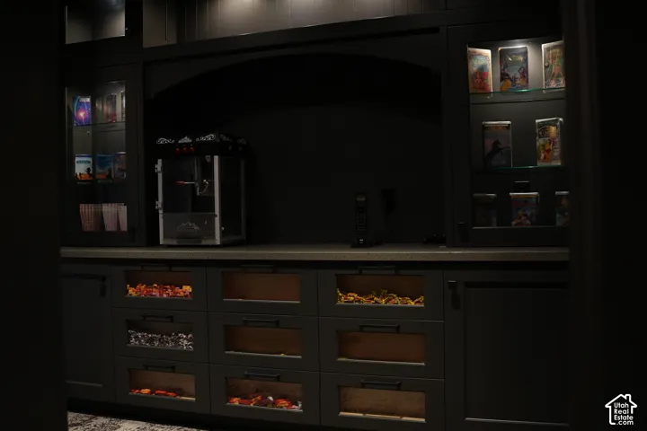Built-in cabinetry with display shelving, under-cabinet lighting, and a solid-surface countertop