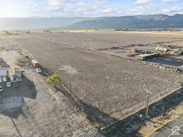 Expansive cleared land parcel bordered by a dirt road and distant mountain range