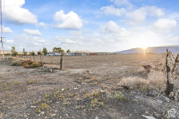 Expansive land parcel featuring a post-and-wire fence and distant mountain range