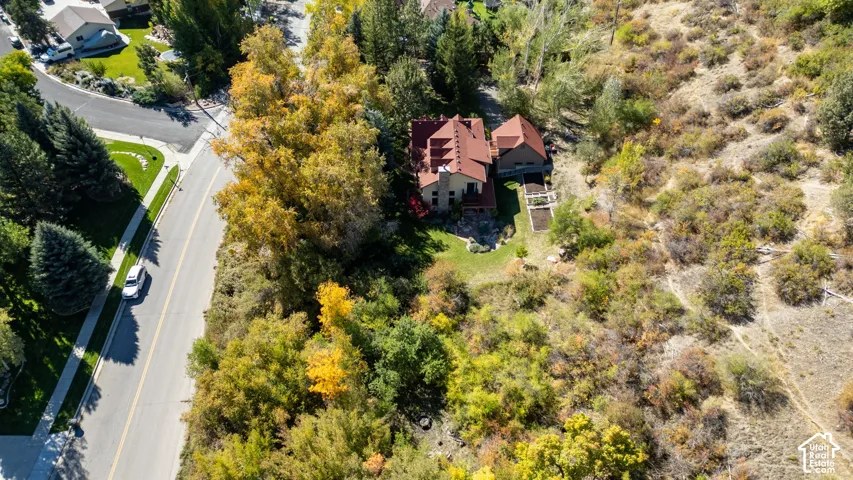 Property featuring a multi-level structure with a red tile roof, surrounded by extensive mature trees and natural landscaping