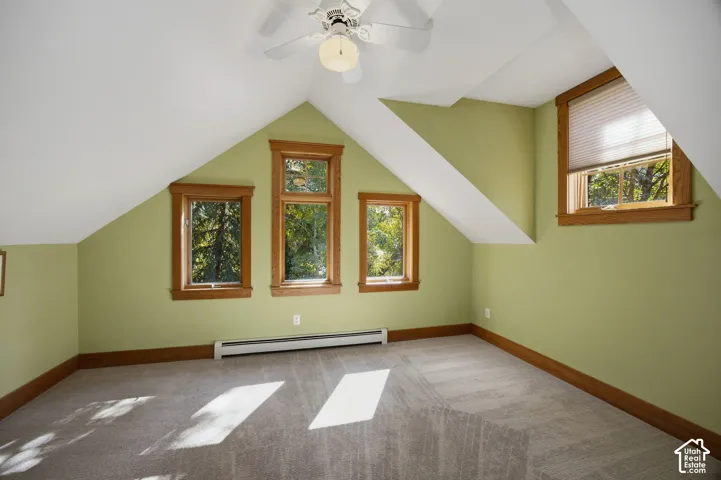 Sloped ceilings with recessed lighting, wood-trimmed windows, wall-to-wall carpeting, and a ceiling fan