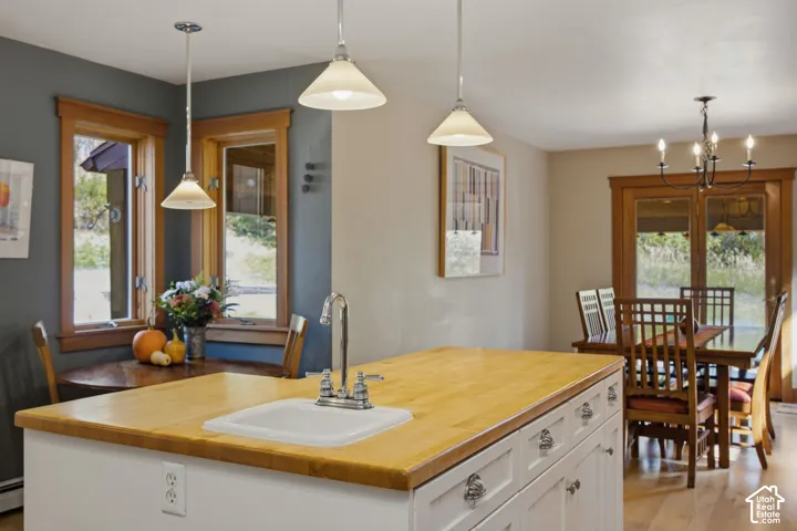 Kitchen island featuring a wood-finish countertop and an integrated sink