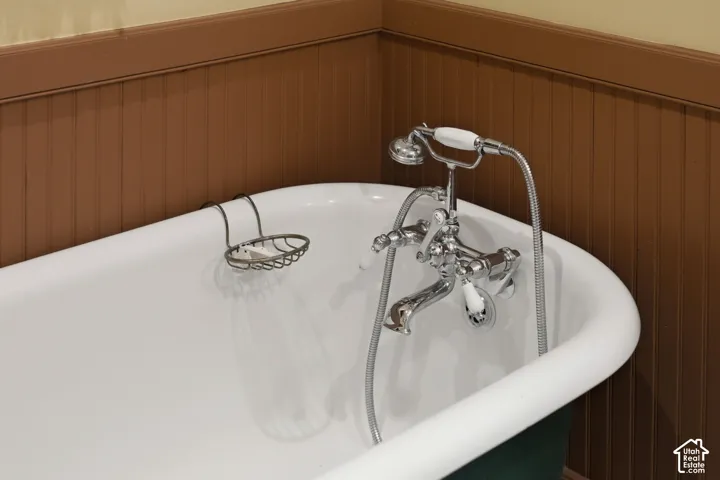 White clawfoot tub with a chrome faucet and handheld shower sprayer